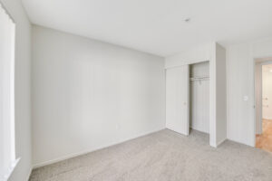 Interior Unit Bedroom, sliding closet, neutral toned carpeting.
