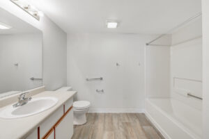 Interior Unit Bathroom, large vanity mirror, storage under sink, laminate countertop, white cabinetry, shower/bathtub.