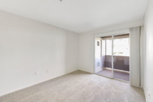 Interior Living room, Neutral toned carpeting, Sliding glass doors leading to outdoor patio/balcony